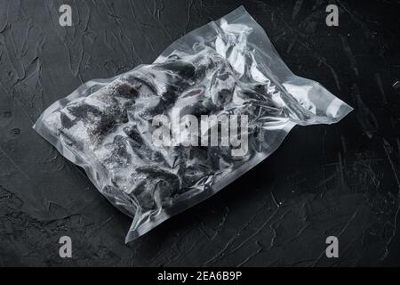 Cozze a guscio intero confezionate sottovuoto congelate, su fondo nero Foto Stock