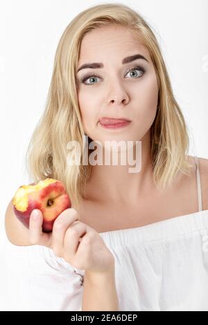Ritratto di bella donna bionda con piacere mangiare nettarine Foto Stock