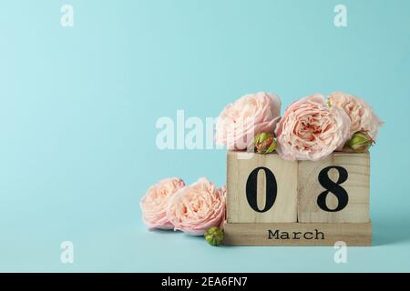 Calendario in legno con 8 marzo e rose su sfondo blu Foto Stock