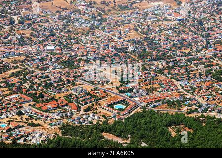 Vista aerea di un quartiere suburbano turco con nuove case in una zona turistica sulla costa mediterranea con piscine e una moschea in lontananza. Foto Stock