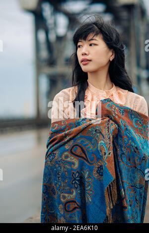 Ritratto di giovane donna giapponese sul ponte avvolto in sciarpa. Foto Stock