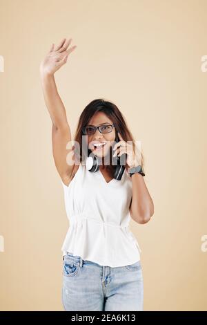 Chiamata donna che agita con la mano Foto Stock
