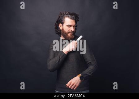 Foto di un bell'uomo che rimuove i peli di animali domestici dal maglione. Foto Stock