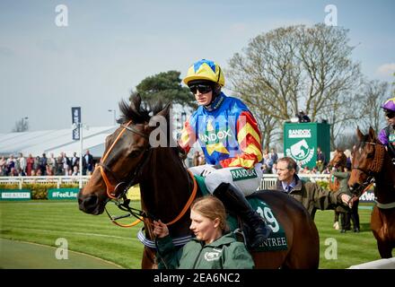 I jockeys al Grand National si fanno strada intorno alla precorsa dell'anello della parata che si tiene annualmente all'Ippodromo di Aintree, vicino a Liverpool, Inghilterra. Foto Stock