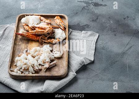 Set di carne di granchio cotti e zampe, su sfondo grigio, con copyspace e spazio per il testo Foto Stock