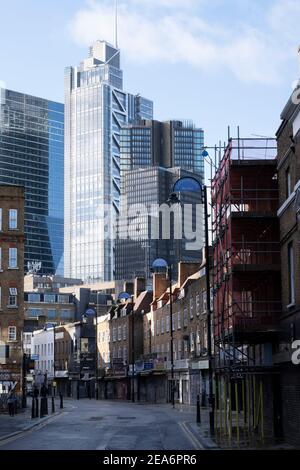 Con le persiane chiuse, tutti i negozi sono chiusi lungo Wentworth Street adiacente alla famosa Petticoat Lane, un'area di mercato della City of London, che è deserta a causa della pandemia di Coronavirus, mentre la chiusura nazionale tre continua il 29 gennaio 2021 a Londra, Regno Unito. Dietro gli edifici vittoriani su questa strada gli alti uffici in vetro della città dominano lo sfondo. A seguito dell'impennata dei casi durante l'inverno, inclusa una nuova variante britannica di Covid-19, questo blocco nazionale consiglia a tutti i cittadini di seguire il messaggio di rimanere a casa, proteggere l'NHS e salvare liv Foto Stock