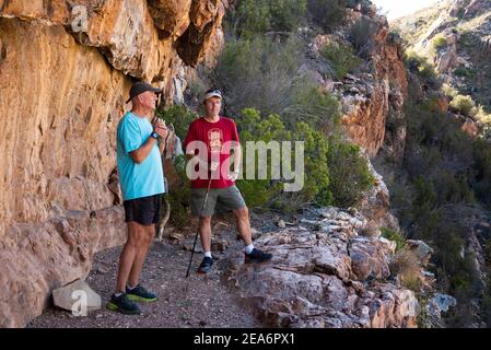 Escursionisti alla grotta d'arte di San Rock a Cedar Falls, Baviaanskloof, Sudafrica Foto Stock