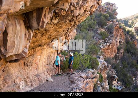 Escursionisti che guardano l'arte di San Rock a Cedar Falls, Baviaanskloof, Sudafrica Foto Stock