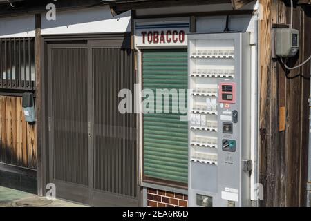 Un minuscolo chiosco chiuso con cassettoni di tabacco in una tranquilla strada posteriore a Nara, Giappone Foto Stock