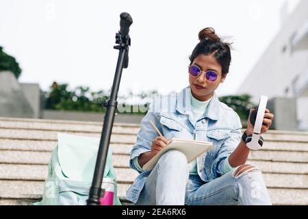 Giovane donna che scrive nel pianificatore Foto Stock