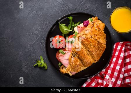 Panino di croissant sul tavolo nero. Foto Stock