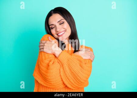 Foto di sognante signora coccole spalle chiuso occhi indossare colore verde scuro isolato con pullover arancione Foto Stock