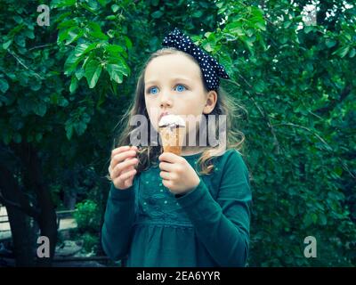Ritratto di una ragazza in piedi in un parco con un gelato, Italia Foto Stock