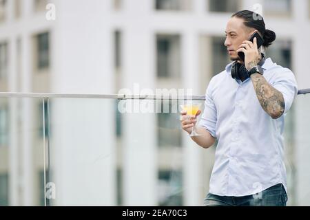 Uomo d'affari accigliato che parla al telefono Foto Stock