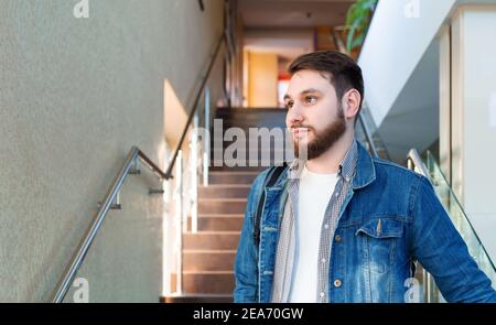Ritratto di giovane uomo d'affari caucasico. Bel studente con la bearded sulle scale dei gradini. Spazio di copia Foto Stock