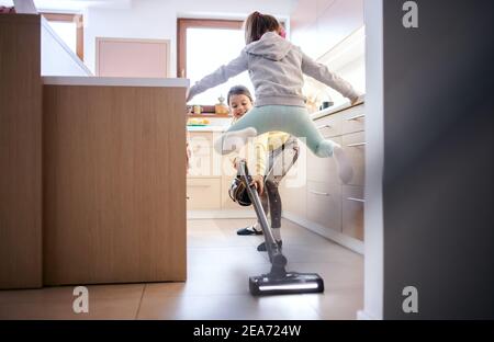 Due piccole sorelle ragazze all'interno a casa, divertendosi quando si aggancia. Foto Stock