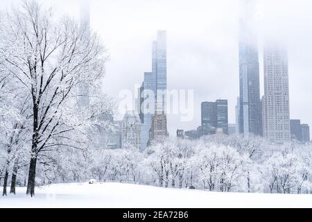 Splendida vista dello skyline di New York City da un Central Park vuoto durante una tempesta di neve pesante. Foto Stock