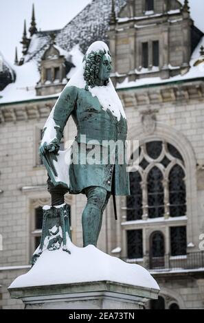 Saale, Germania. 8 febbraio 2021. 08 febbraio 2021, Sassonia-Anhalt, Halle (Saale): Una cappa bianca di neve copre il monumento a George Frideric Handel sulla piazza del mercato di Halle/Saale. La forte caduta di neve porta a notevoli ostacoli su strade, ferrovie e sentieri. Foto: Hendrik Schmidt/dpa-Zentralbild/dpa Credit: dpa Picture Alliance/Alamy Live News Foto Stock