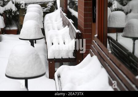 Saale, Germania. 8 febbraio 2021. 08 febbraio 2021, Sassonia-Anhalt, Halle (Saale): La neve giace sui tavoli e sulle panchine di una caffetteria nel pub Mile. Una forte caduta di neve porta a notevoli ostacoli su strade, ferrovie e sentieri. Foto: Hendrik Schmidt/dpa-Zentralbild/ZB Credit: dpa Picture Alliance/Alamy Live News Foto Stock