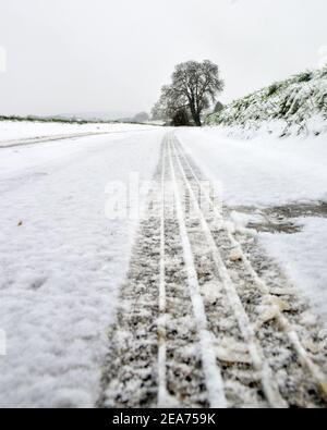 Pista da neve su una strada innevata durante l'inverno Foto Stock