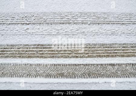 Differenza su una strada innevata tra uno pneumatico standard e. una ruota da neve con cingoli per pneumatici Foto Stock