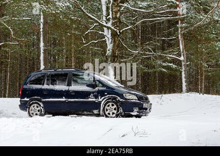 Riga, Lettonia - 30 gennaio 2021: Auto blu OPEL Zafira parcheggiata nella foresta invernale Foto Stock