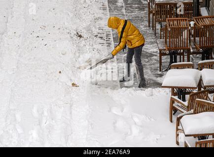 Dresda, Germania. 8 febbraio 2021. Un uomo tovola la neve di fronte a un ristorante a Münzagasse, nella Città Vecchia. Credit: Robert Michael/dpa-Zentralbild/dpa/Alamy Live News Foto Stock