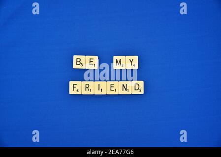 Scrabble tessere su sfondo blu ortografia essere il mio amico Foto Stock