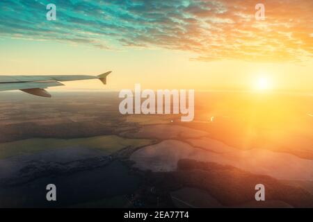 Tramonto colorato e pittoresco dalla finestra dell'aereo durante il volo. Foto Stock