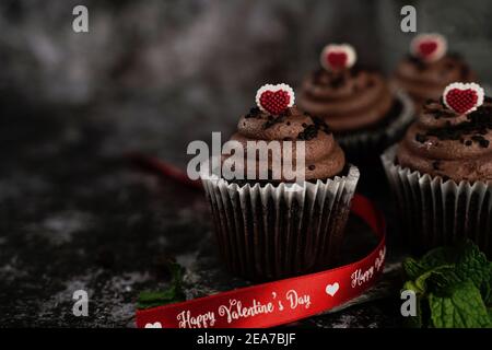 San Valentino Cupcakes cioccolato su impostazione moody scuro, fuoco selettivo Foto Stock
