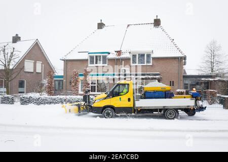 Pala gommosa da neve, sbrinando una strada mentre si diffonde il sale Paesi Bassi Foto Stock