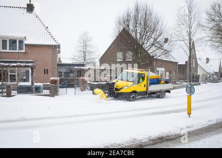 Pala gommosa da neve, sbrinando una strada mentre si diffonde il sale Paesi Bassi Foto Stock