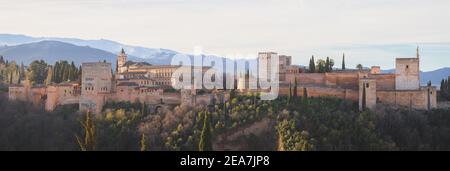 Vista panoramica classica dell'alba sul Palazzo Carlo V, sull'iconica Alhambra e sulle montagne della Sierra Nevada dal Mirador de San Nicolas nella città vecchia di albaicin Foto Stock