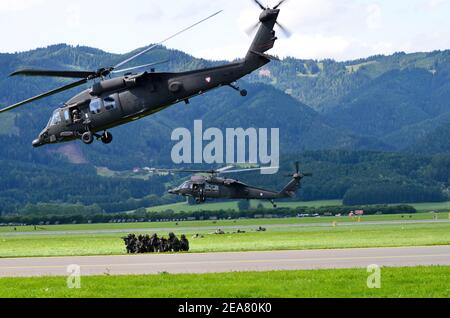 Zeltweg, Austria - 1 luglio 2011: Esercizio in campo con truppe armate ed elicotteri Black Hawk dell'esercito austriaco da parte di un pubblico Airshow - airpower11 - Foto Stock