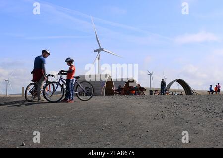 Un padre e un figlio con le bici prendono un pitstop nell'area picnic sulla fattoria di vento di Whitelee, la brughiera di Eaglesham, Scozia, Regno Unito Foto Stock