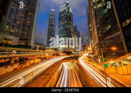 Lunga esposizione di Hong Kong cityscape skyscaper che hanno luce Trasporto stradale da auto o autobus nel quartiere Centrale degli Affari Intorno a IFC buildin Foto Stock