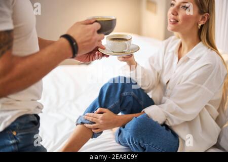 Donna che ottiene il suo caffè servito a letto Foto Stock