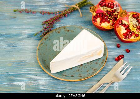 Pezzo di formaggio chiaro brie su sfondo di legno blu. Foto studio Foto Stock