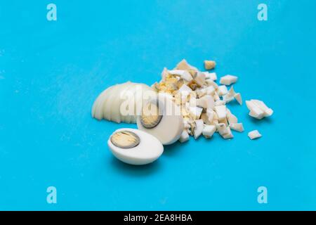 Uova bollite tagliate o tagliate a pezzi piccoli su un Tagliere Foto Stock