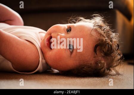 Bambino giacente sul retro sorridente Foto Stock