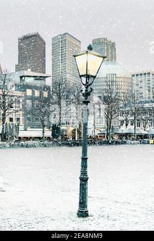 Vista invernale serale con lanterna del centro di l'Aia Con la piazza 'Plein' durante la nevicata Foto Stock