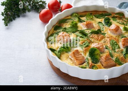 Frittata all'uovo, omelette con salmone, broccoli e spinaci. Piatto italiano, quiche croccanti Foto Stock