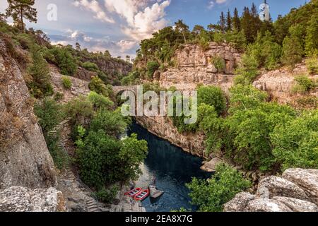 Antico ponte ad arco sulla gola del fiume Kopruray nel Parco Nazionale di Koprulu in Turchia. Vista panoramica del canyon e delle montagne dalle tempeste blu riv Foto Stock