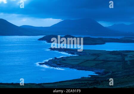 Le onde si infrangono nelle ore precedenti l'alba al faro dell'isola di Valentia a Cromwell Point, Valentia, Irlanda. Foto Stock