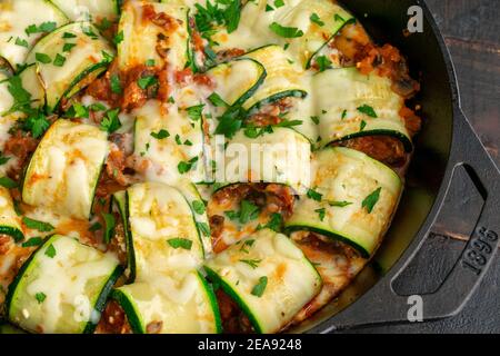 Involtini di zucche Lasagna in una padella di ghisa: Zucchine ripieni di formaggi italiani, funghi e salsa di pomodoro Foto Stock