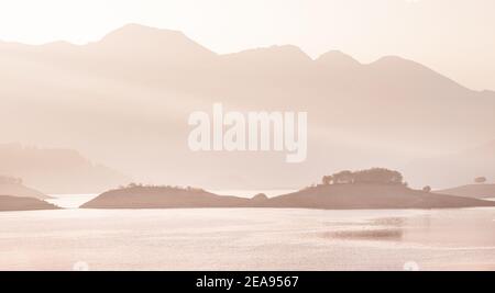 Paesaggio panoramico all'alba al mattino. Natura idilliaca con le sagome dei monti Taurus. Lago di Karacaoren nella regione Ispartana del Turco Foto Stock