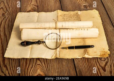 Penna a fontana e lente d'ingrandimento con vecchi fogli in legno sfondo Foto Stock