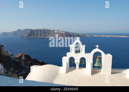 Grecia, Santorini, un campanile bianco di una chiesa che domina la caldera risultante dal collaspa del vulcano, formando un paesaggio ladscape unico. Foto Stock
