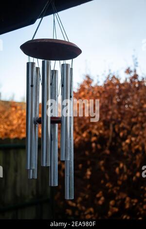 Metallo vento chimes decorazione appesa in un giardino con autunno o colori autunnali Foto Stock