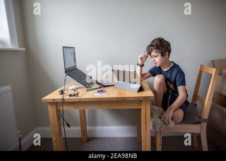 Ragazzo di 7 anni che ha una lezione privata di educazione attraverso una chiamata zoom a casa , Londra, Inghilterra, Regno Unito Foto Stock